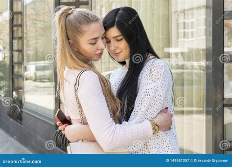 two women hugging on a city street stock image image of blonde