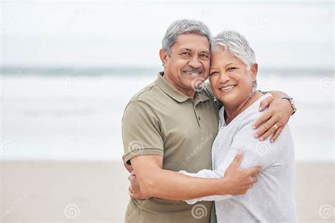 Senior Couple Portrait And Hug At Beach For Holiday Vacation Or