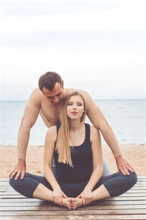 de mens en het zwangere meisje doen yoga op zee kust stock foto image  actief gezondheid