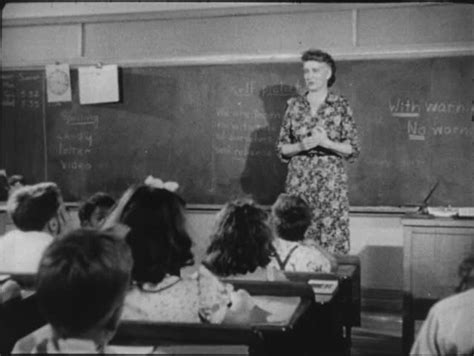 1950s Teacher In Front Of Classroom Writing Confidence On Blackboard