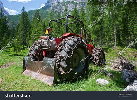logging tractor equipped chains forest mountains stock photo