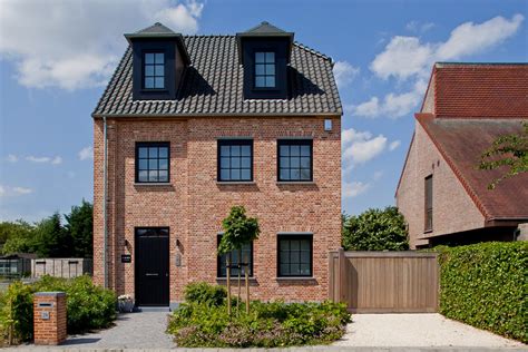 brick house  black shutters   front  side windows surrounded  greenery