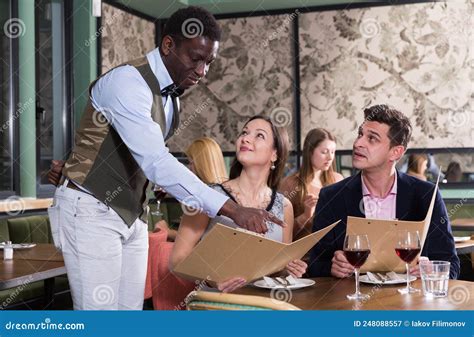 African American Waiter Helping Couple With Menu Stock Image Image Of