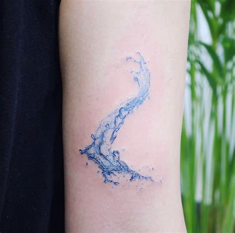 blue ink tattoo   arm   womans left arm  water