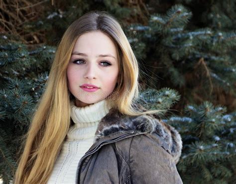 cute beautiful teenage girl sitting in the snow stock