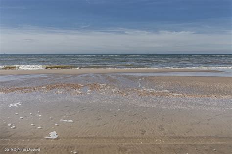 zeezicht   strandwandeling bij opkomend water flickr