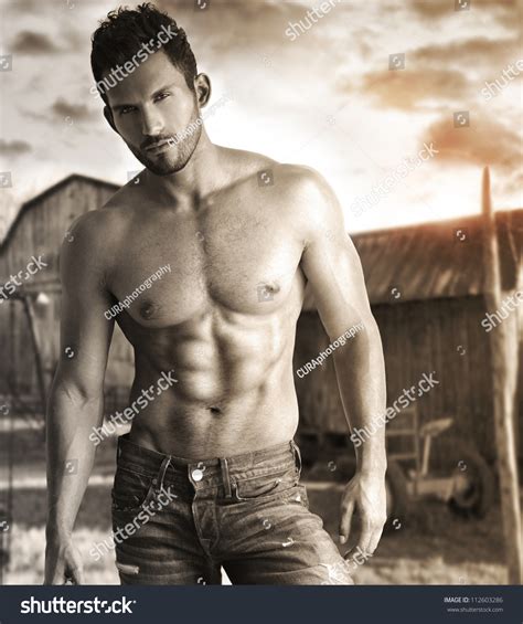 sepia toned portrait of a hunky male model in nostalgic outdoor rustic