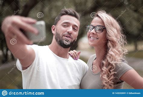 Close Up Smiling Young Couple Taking Selfie In City Park Stock Image