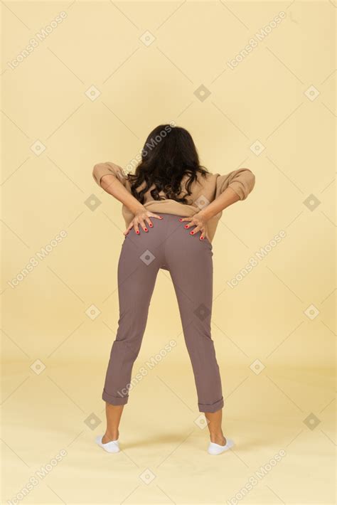 foto de vista posterior de una mujer joven de piel oscura poniendo las