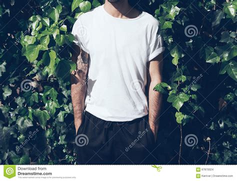 bearded man  tattoo wearing blank white tshirtgreen garden wall background horizontal