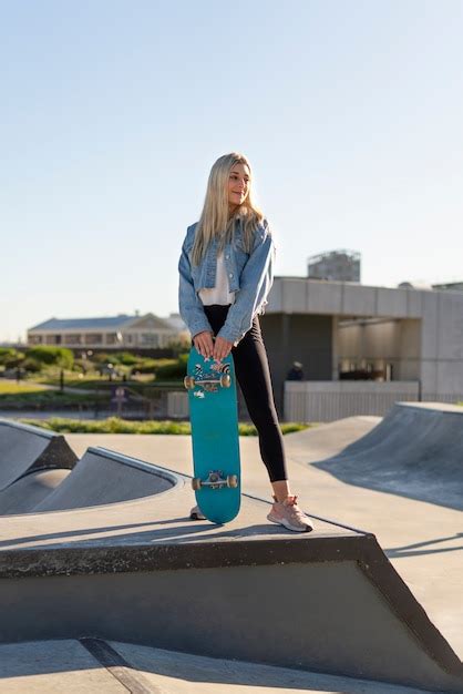 smiley mädchen der vorderansicht das skateboard hält kostenlose foto