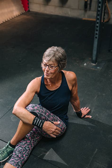 senior woman stretching at gym by rzcreative