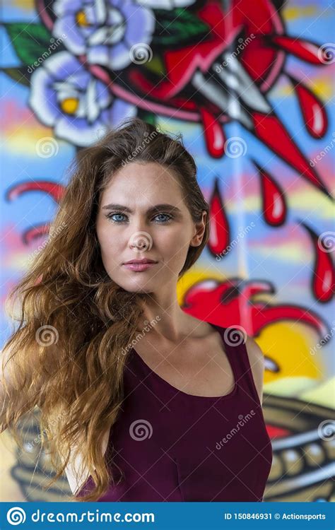 Lovely Brunette Model Posing Outdoors Against Graffiti Stock Image
