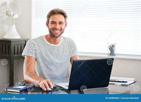 tech savvy young man smiling  camera sitting  computer stock