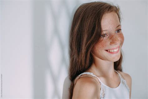 side view portrait of beautiful girl with freckles smiling stocksy united