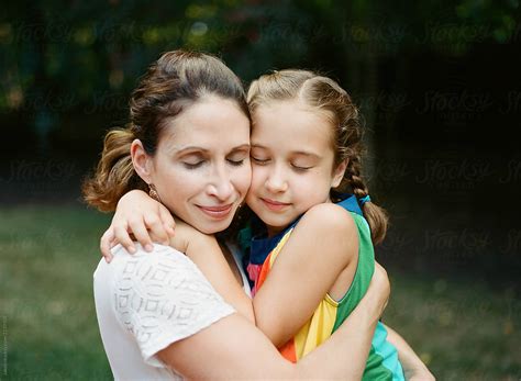 daughter embracing mother with eyes closed del colaborador de stocksy