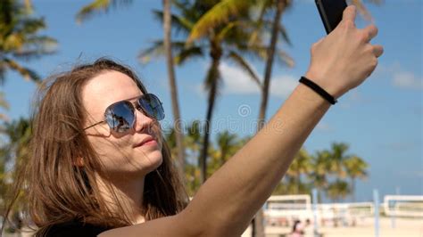 Jovem Que Leva Uma Selfie Debaixo De Palmeiras Na Praia Imagem De Stock