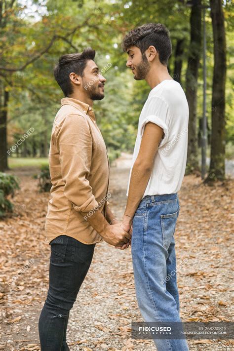 Happy Young Gay Couple Holding Hands In Autumnal Park — Young Men Face