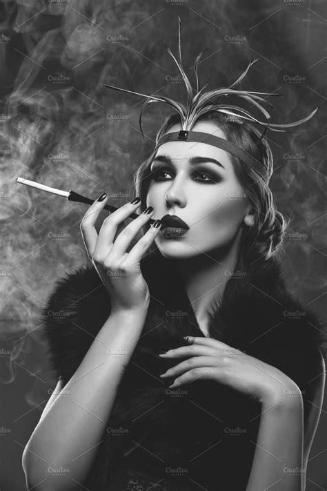 beautiful girl with smoky eyes and red lips holding cigarette high