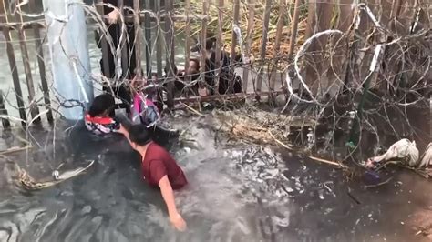 us border crisis migrants go under border fence in us agents video