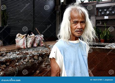 An Adult Filipino Man With Long Gray Hair Pose For The Camera Editorial