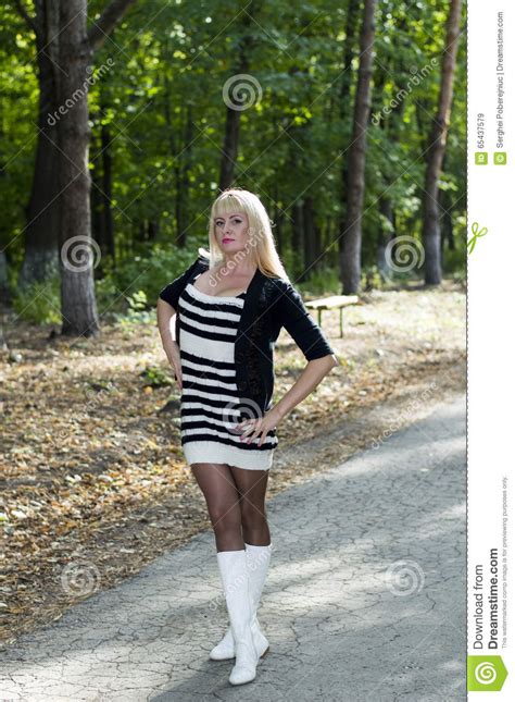 die schöne blondine in den weißen stiefeln auf einem weg im park stockbild bild von kühl