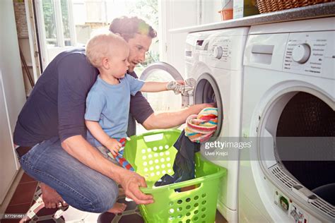 Father And Son Doing Laundry Together Photo Getty Images