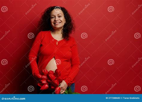 Beautiful Curly Haired Brunette Pregnant Woman Holding Bouquet Of Red