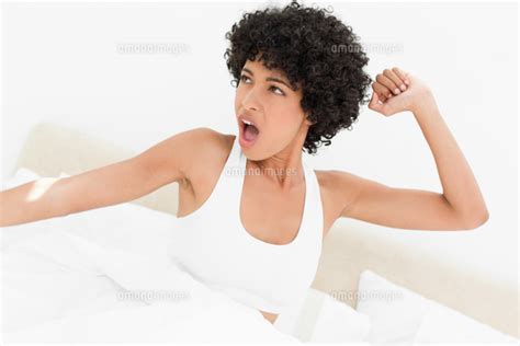 Attractive Frizzy Haired Woman Yawning And Stretching Her Arms