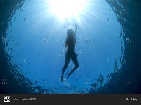 underwater view  woman swimming   oceans blue water stock photo