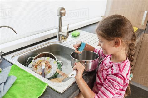 smiling girl washing dishes  kitchen sink stock photo dissolve