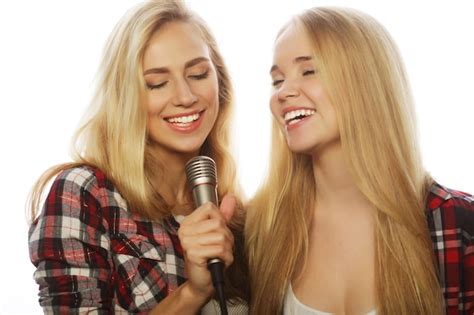 Premium Photo Two Beauty Girls With A Microphone Singing And Having Fun