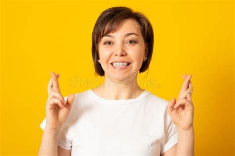 Pleased Cheerful Brunette Woman Puts All Efforts In Wishing Good Luck