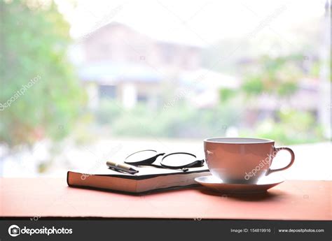 Coffee Cup With Book Pen And Glasses On A Wooden Table
