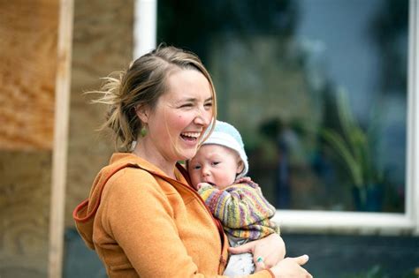 a candid photo of eve kilcher laughing happily with her newborn son findlay in her arms atlf