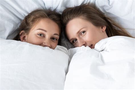 Two Lesbians Lying Under White Blanket In Bedroom Stock Image Image