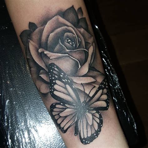 Wonderful Black Ink Rose And Butterfly Tattoo On Forearm