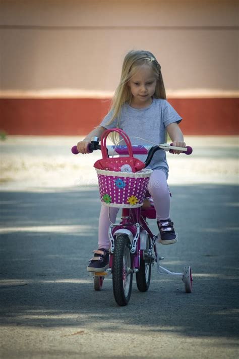 little blond girl rides a bicycle on a sunny day stock image image of