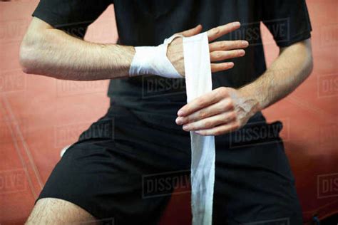 boxer bandaging hands before putting on gloves mid section stock