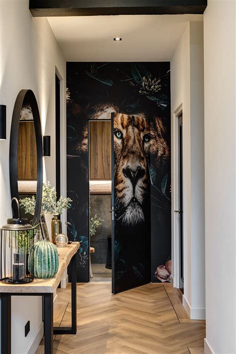 landhuis met verdekt toilet achter een deur met behang van een leeuwenkop hal met visgraat