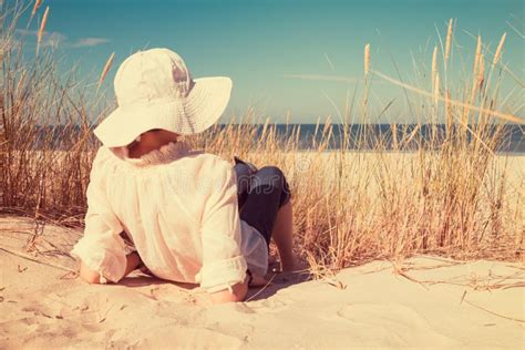 dame  op zand liggen en hoed die op zee kijken stock afbeelding image  horizontaal