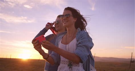 Happy Couple Taking Selfie On Beach At Sunset Using Phone