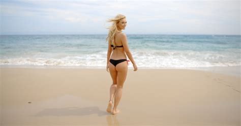 Rear View Of Woman In Bikini Looking Back On Beach By