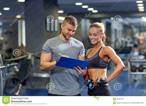 Smiling Young Woman With Personal Trainer In Gym Stock Image Image Of