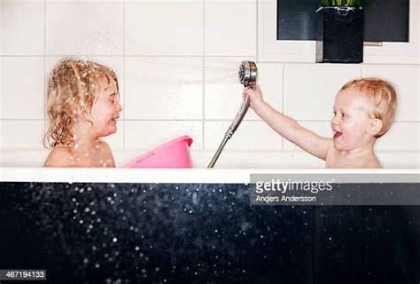 brother and sister taking a bath together photos et images de