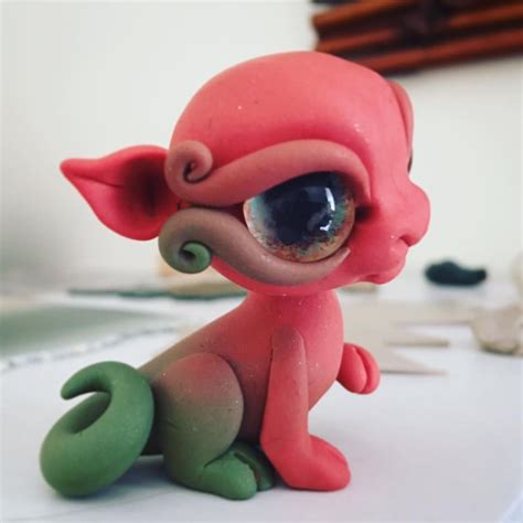 a pink and green figurine sitting on top of a table