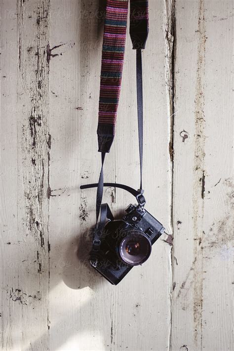 vintage 35mm camera hanging on an old door by helen rushbrook