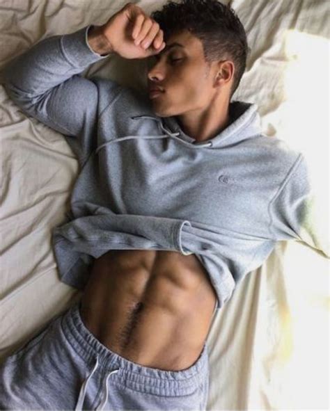 a man laying on top of a bed with his stomach exposed