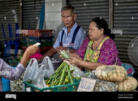senior husband and wife street food market vendors elderly working