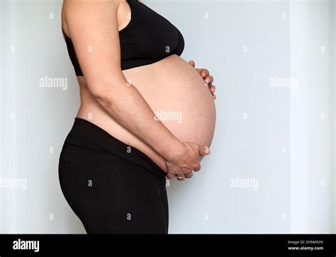 side view at pregnant caucasian woman with big belly female holding